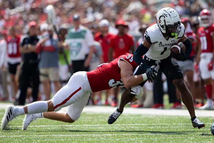 Miami (Oh) Redhawks linebacker Ryan McWood (35) takes down Cincinnati Bearcats wide receiver Tre Tucker (1) during the second quarter of the NCAA football game between the Cincinnati Bearcats and the Miami RedHawks at Paycor Stadium in Cincinnati on Saturday, Sept. 17, 2022. The Cincinnati Bearcats defeated the Miami (Oh) Redhawks 38-17 in the 126th Battle for the Victory Bell. Cincinnati Bearcats Football Vs Miami Redhawks Sept 17 2022